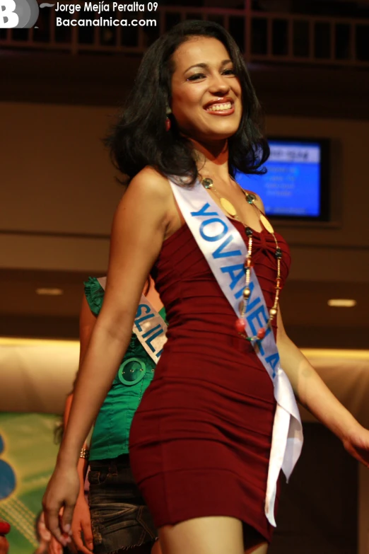 a woman wearing a red dress with an award belt