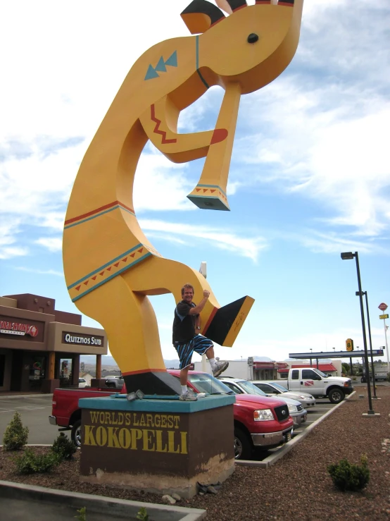 a large, yellow bear statue outside of a gas station