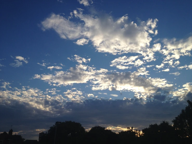 a beautiful cloud formation and blue sky with trees