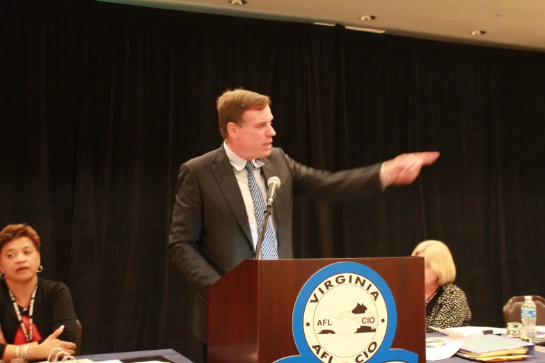 a man wearing a suit and tie making a presentation