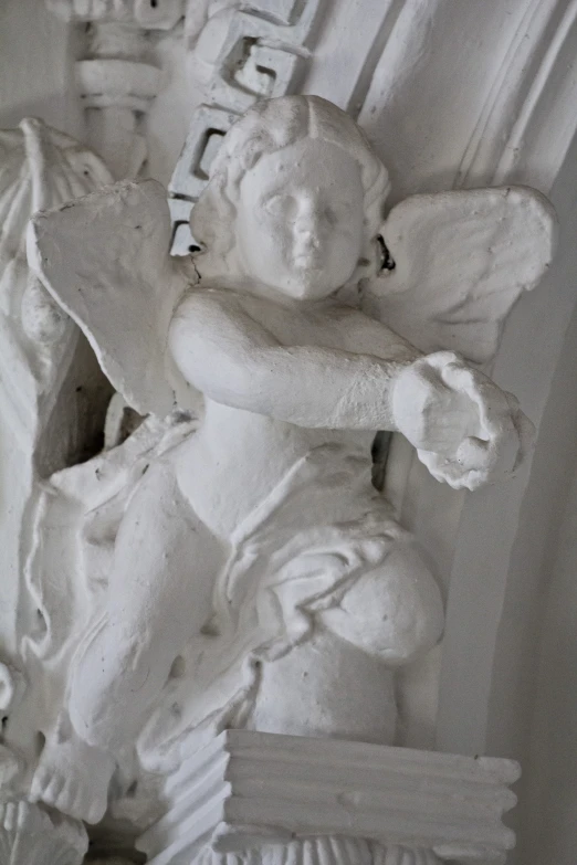 an angel statue on display in a white room