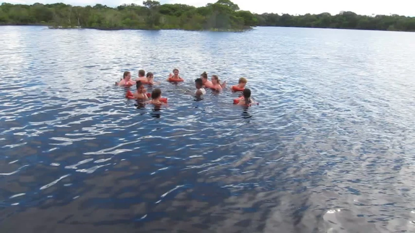 four adults and eight children floating in a lake