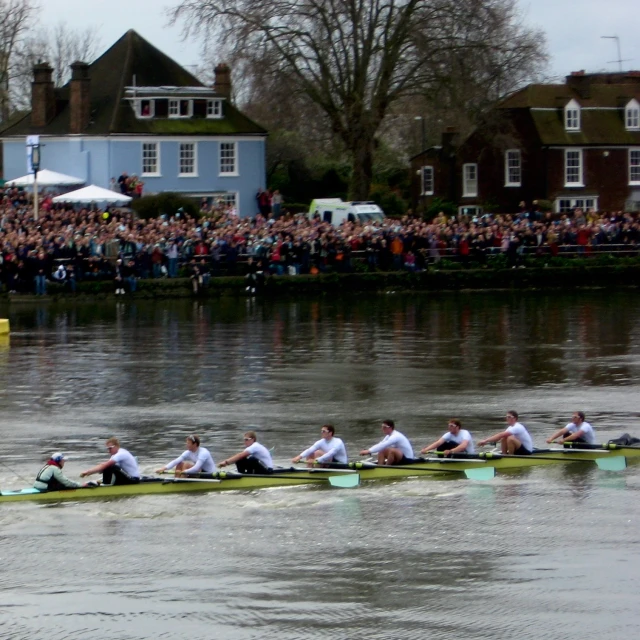 a group of people in white shirts rowing a boat