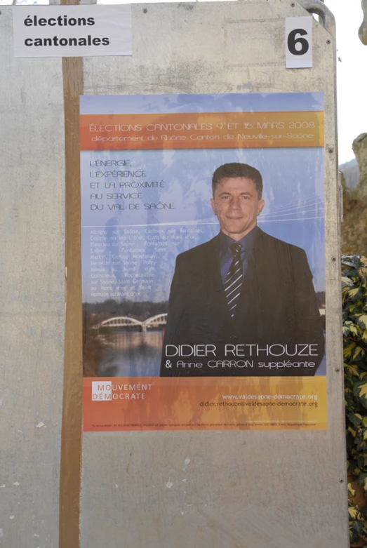 a political poster is attached to a stone wall