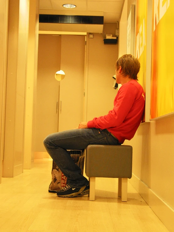 a man sitting on a bench in a hallway