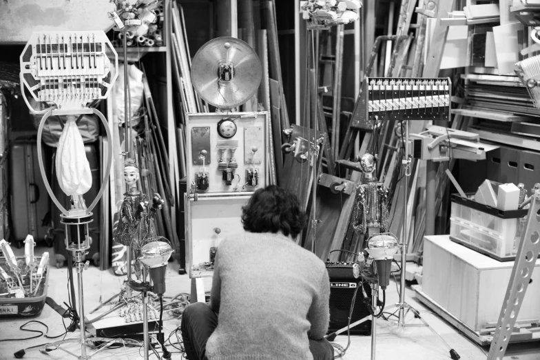 a man sitting next to an assortment of musical instruments