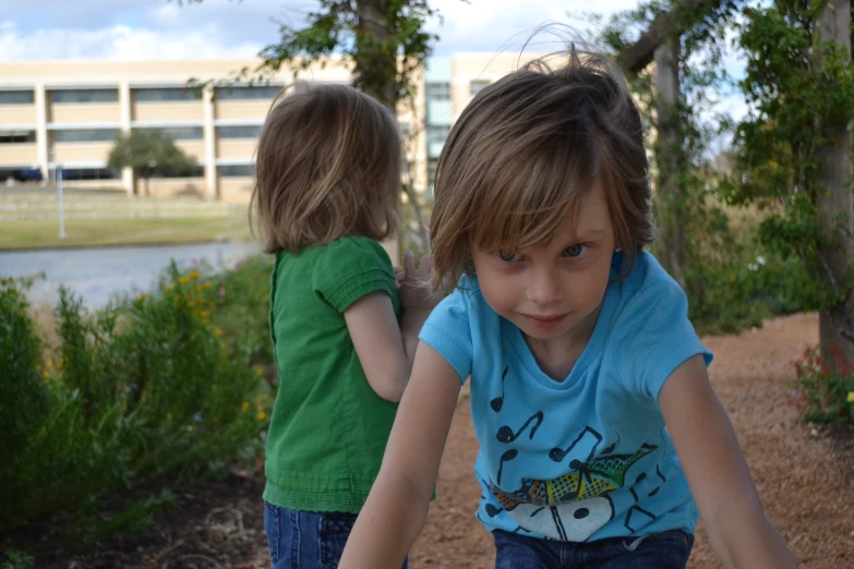 two small children playing with a disc golf ball