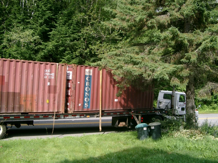 a large, semi - truck hauling a long cargo trailer down a road