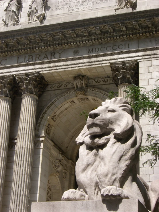 a tall lion statue sitting below the arches of an entrance