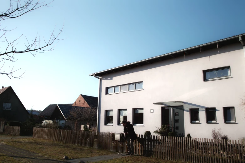 two people standing outside the front of a house