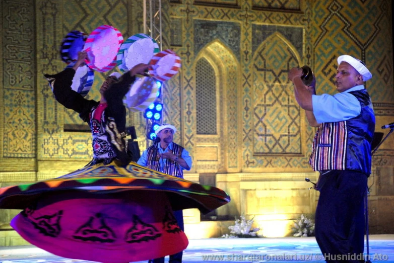 three performers dressed in oriental costumes are performing
