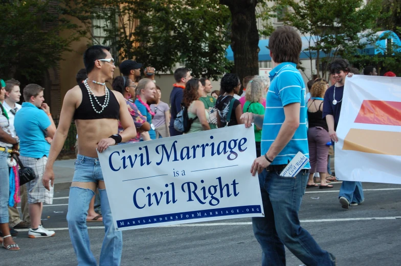 two men in a bikini holding a civil rights sign