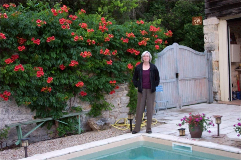 a woman in a purple shirt standing in front of a pool