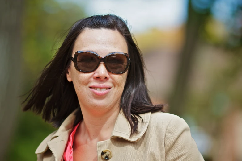 a women with a pretty pink shirt and some sunglasses