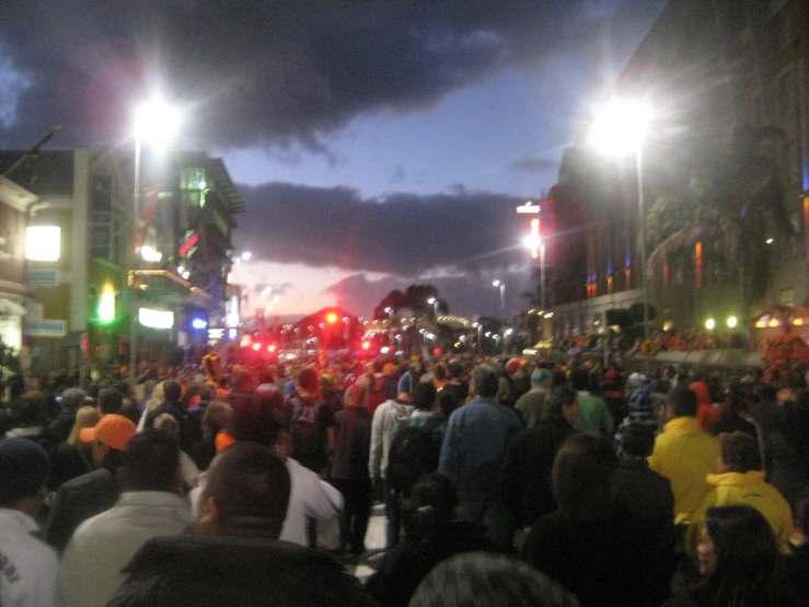 people walk down the crowded city street at night