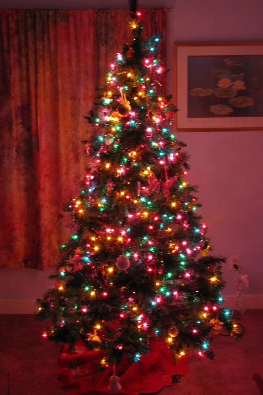 a small lit christmas tree with presents under it