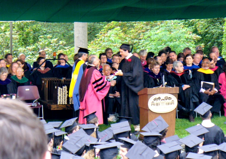 a speaker and graduates under the stage during graduation