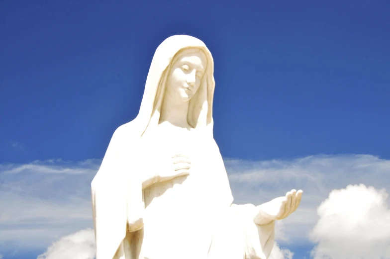 the statue is white against a blue sky