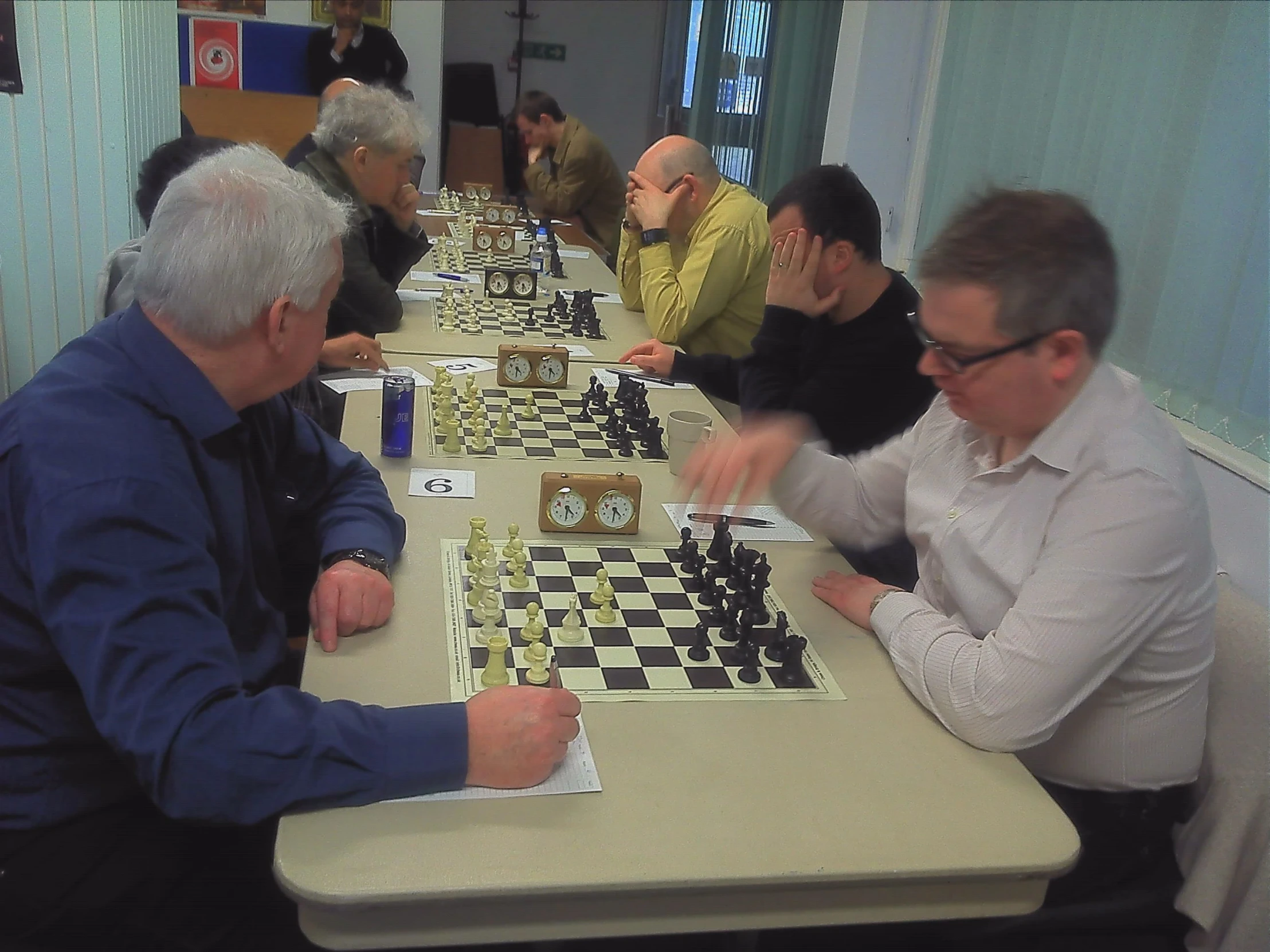 several older men playing chess at a restaurant