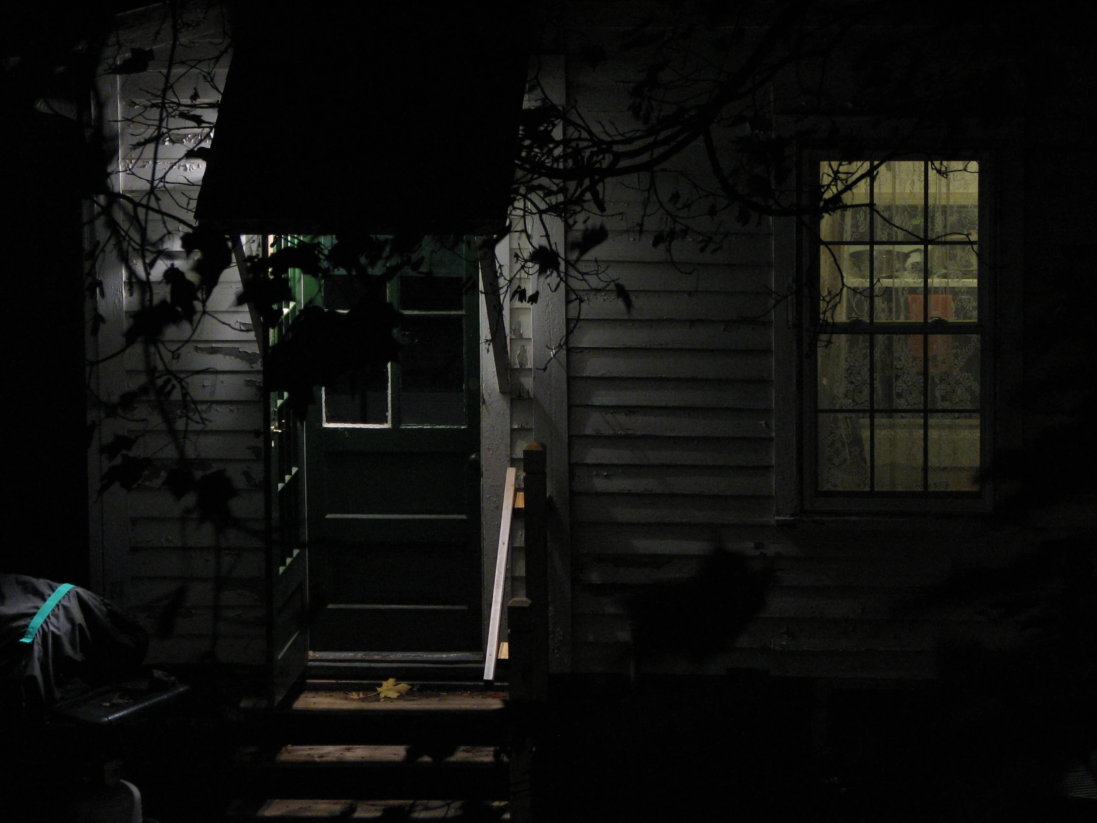 an open doorway to the house with steps going up it at night