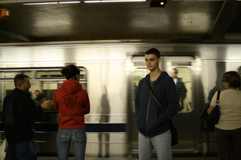 a group of people at the subway platform waiting for the subway