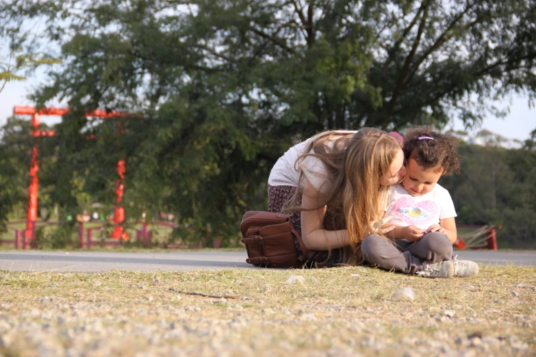 a man kneeling down with a baby next to a woman