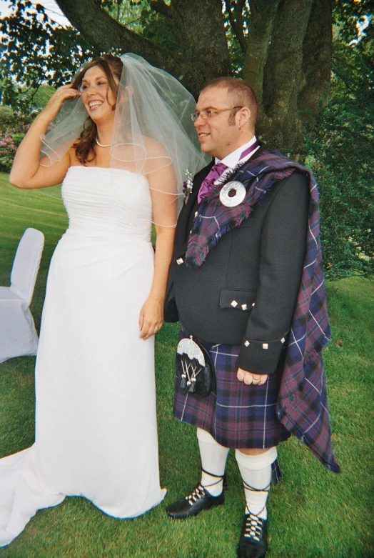 a married couple in traditional scottish attire posing together