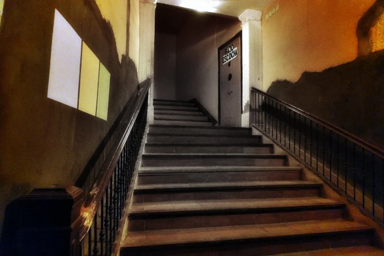 a hallway with steps to the bottom of each step leading to a clock