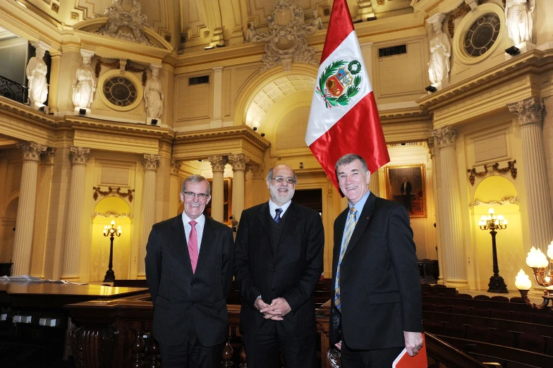 two men standing in front of a flag in a building