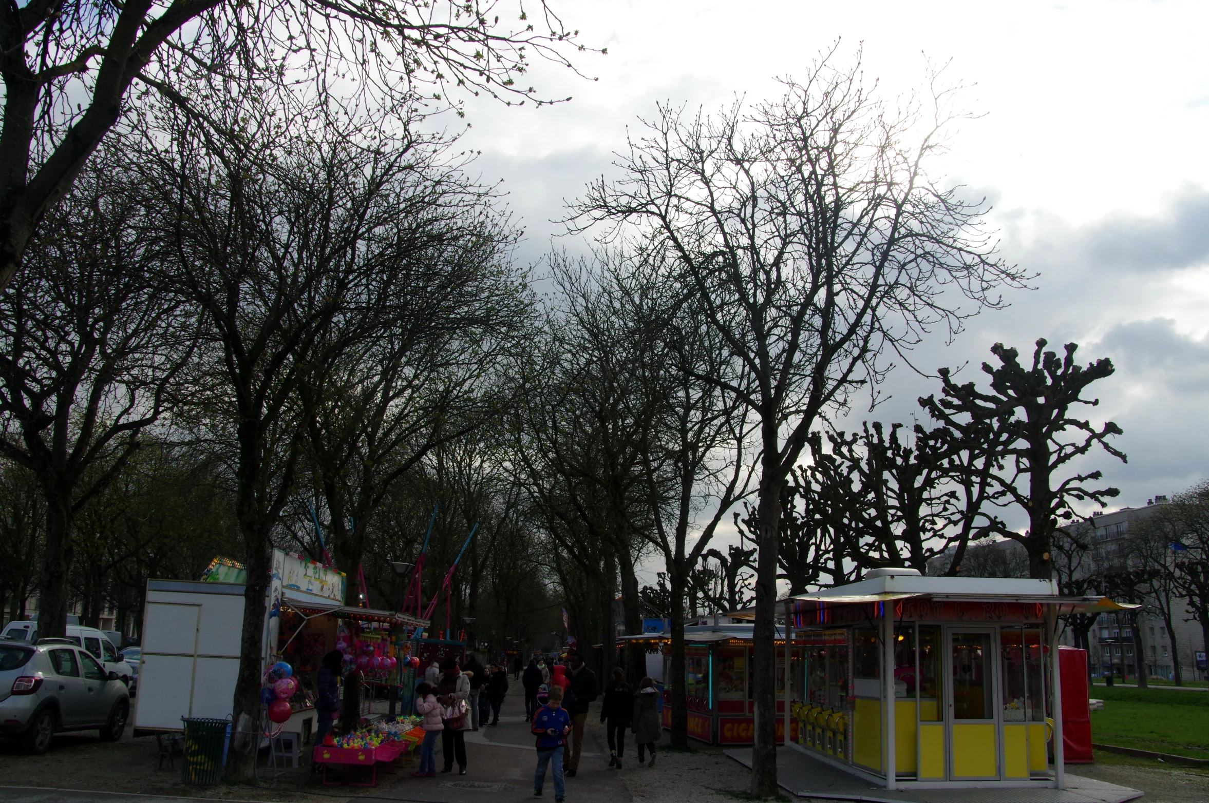 a street view of some people and parked cars