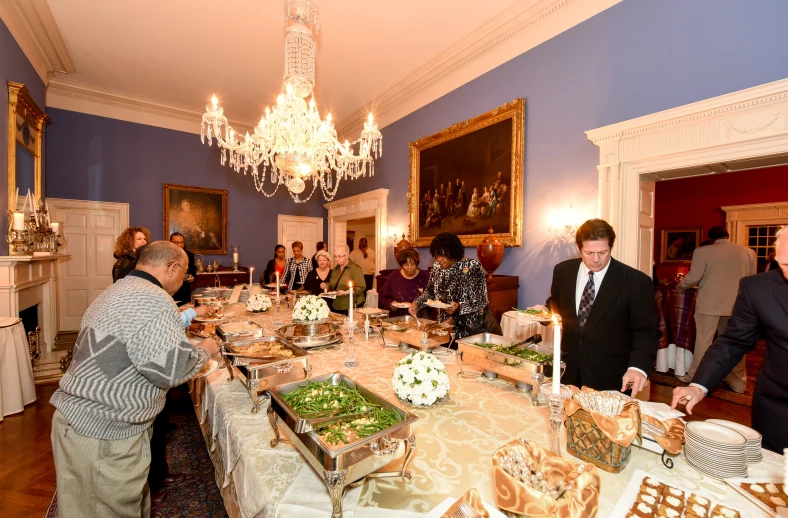 a group of people standing around a dining room table