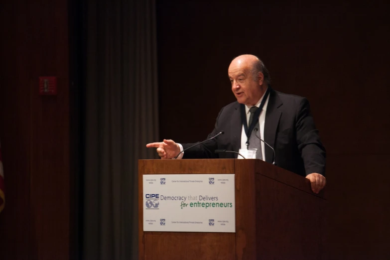 a man in a suit speaking from a podium