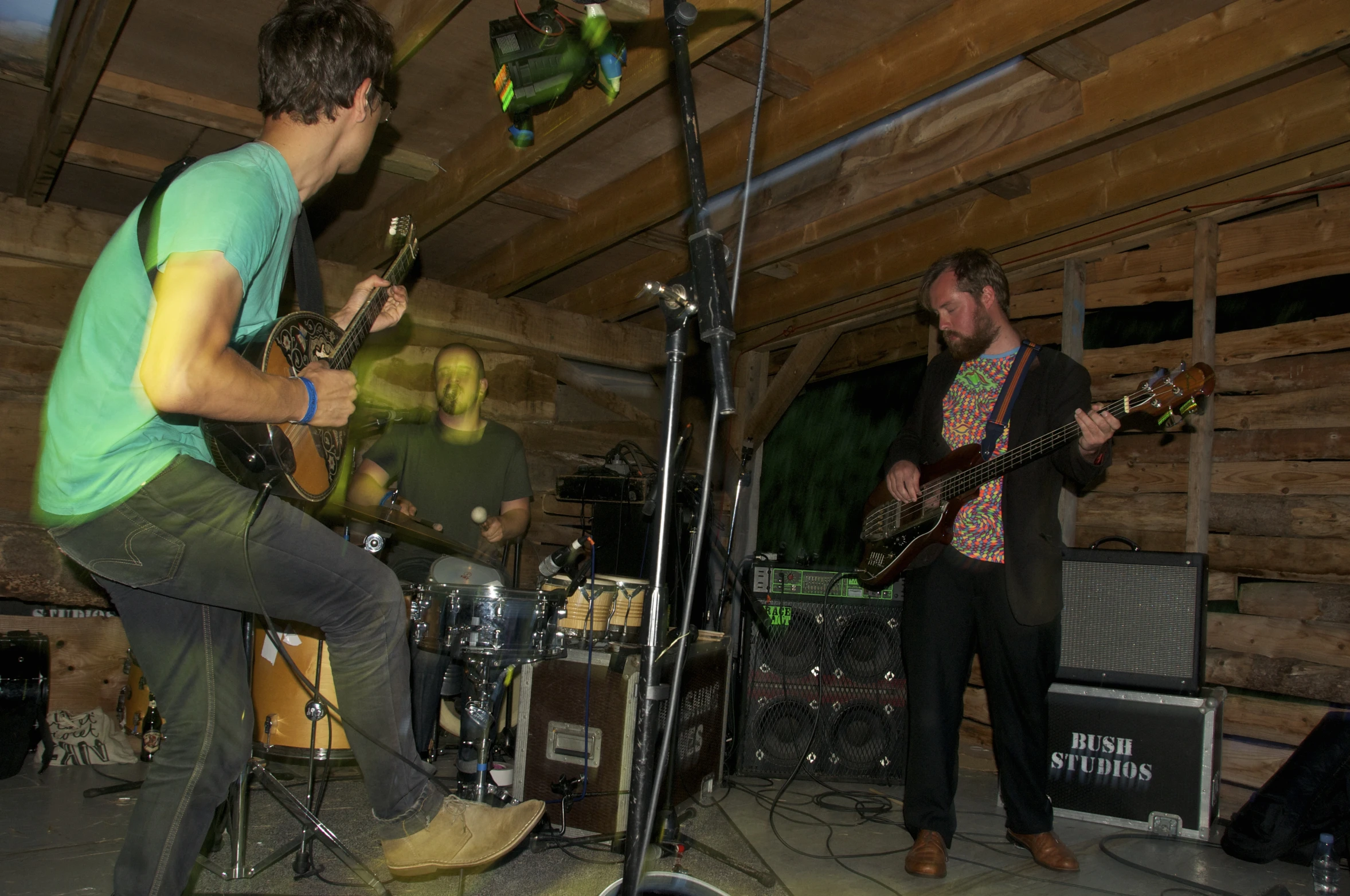 a man playing guitar while another man plays the drums