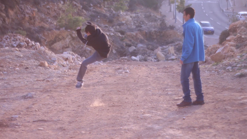 two young men are playing frisbee in the field