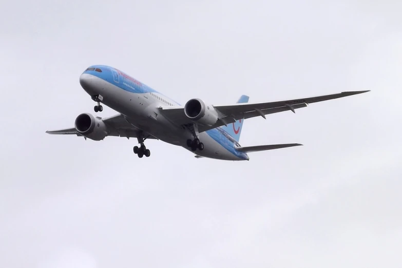 a blue and silver airplane is flying through the air