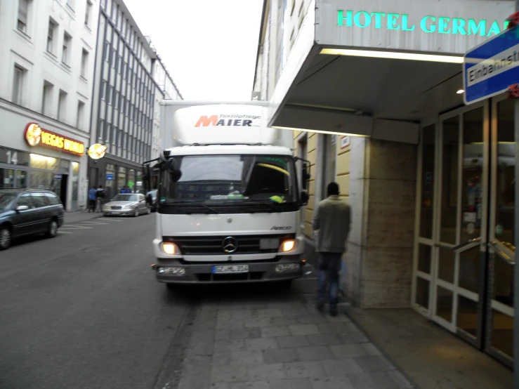 a big white bus is parked at the side of a road