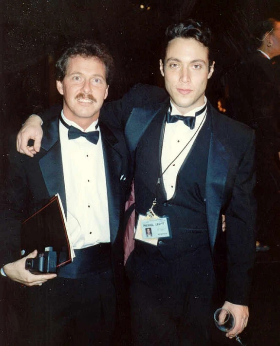 two men in formal wear pose for a po