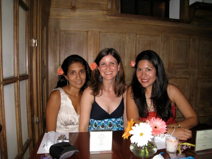 three woman at a restaurant posing for the camera