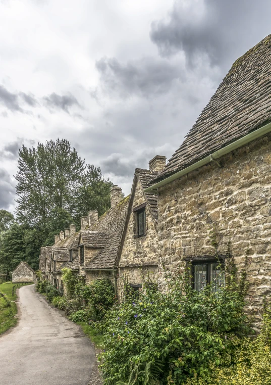 the stone buildings are lined with bushes and trees