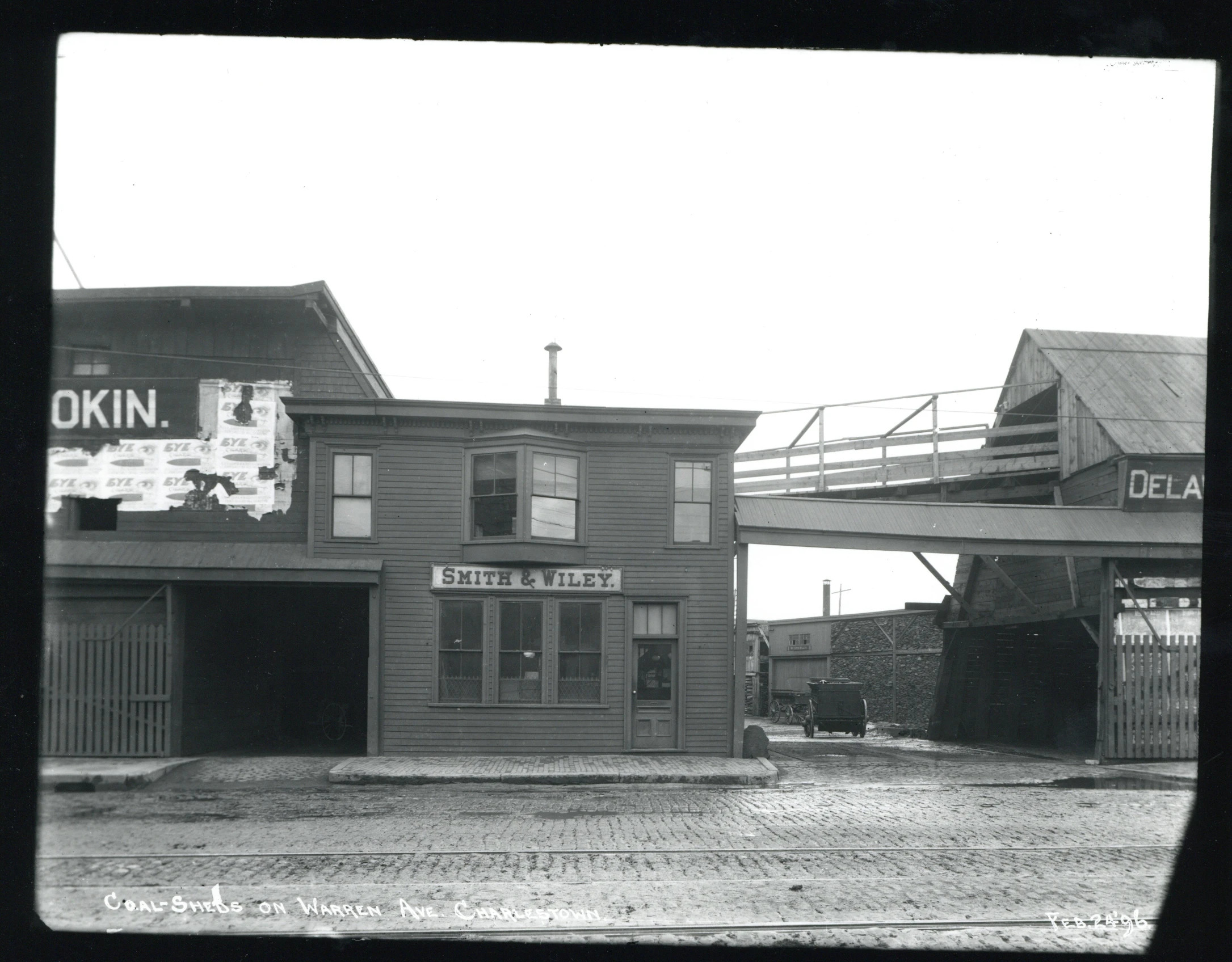 a black and white picture of buildings with a train bridge over them