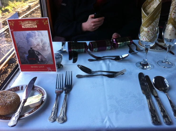 a table topped with silverware and cards next to a window