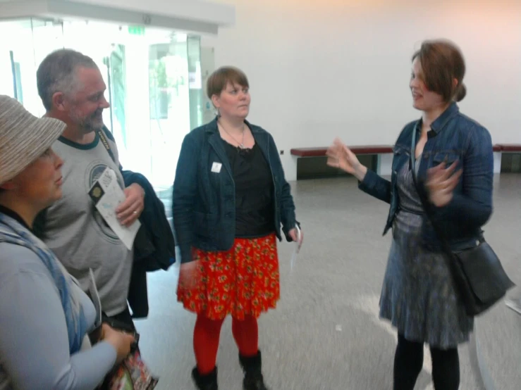 a woman talks to some people in an empty room