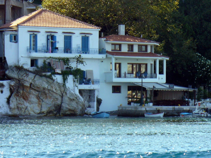 a large home sitting on top of a hill next to a body of water