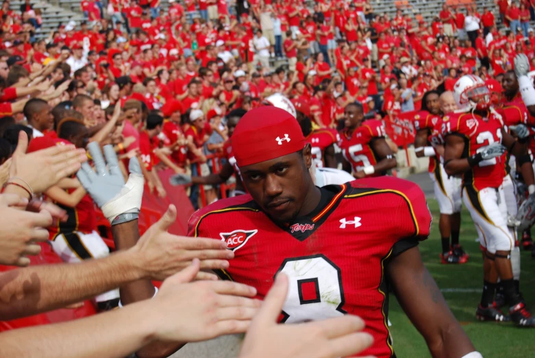 football players in red uniforms with their hands in the air