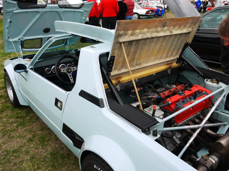 a man is looking at a very old muscle car