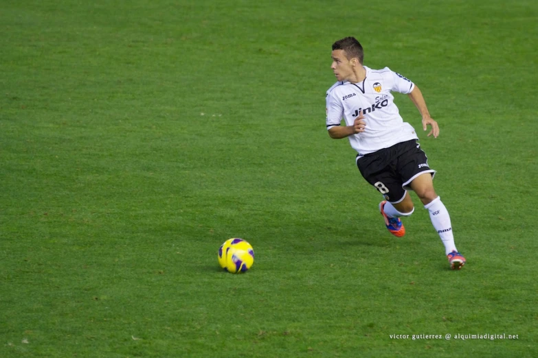 a man running after a soccer ball on a field