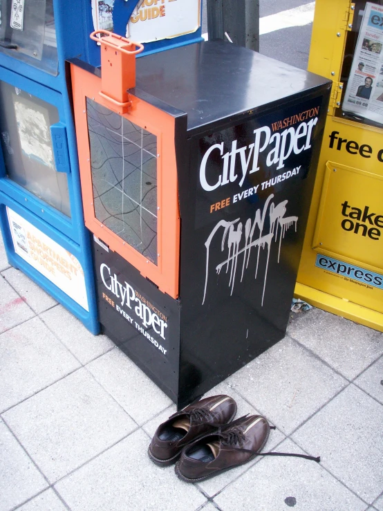 a shoe laying by a street advertit kiosk