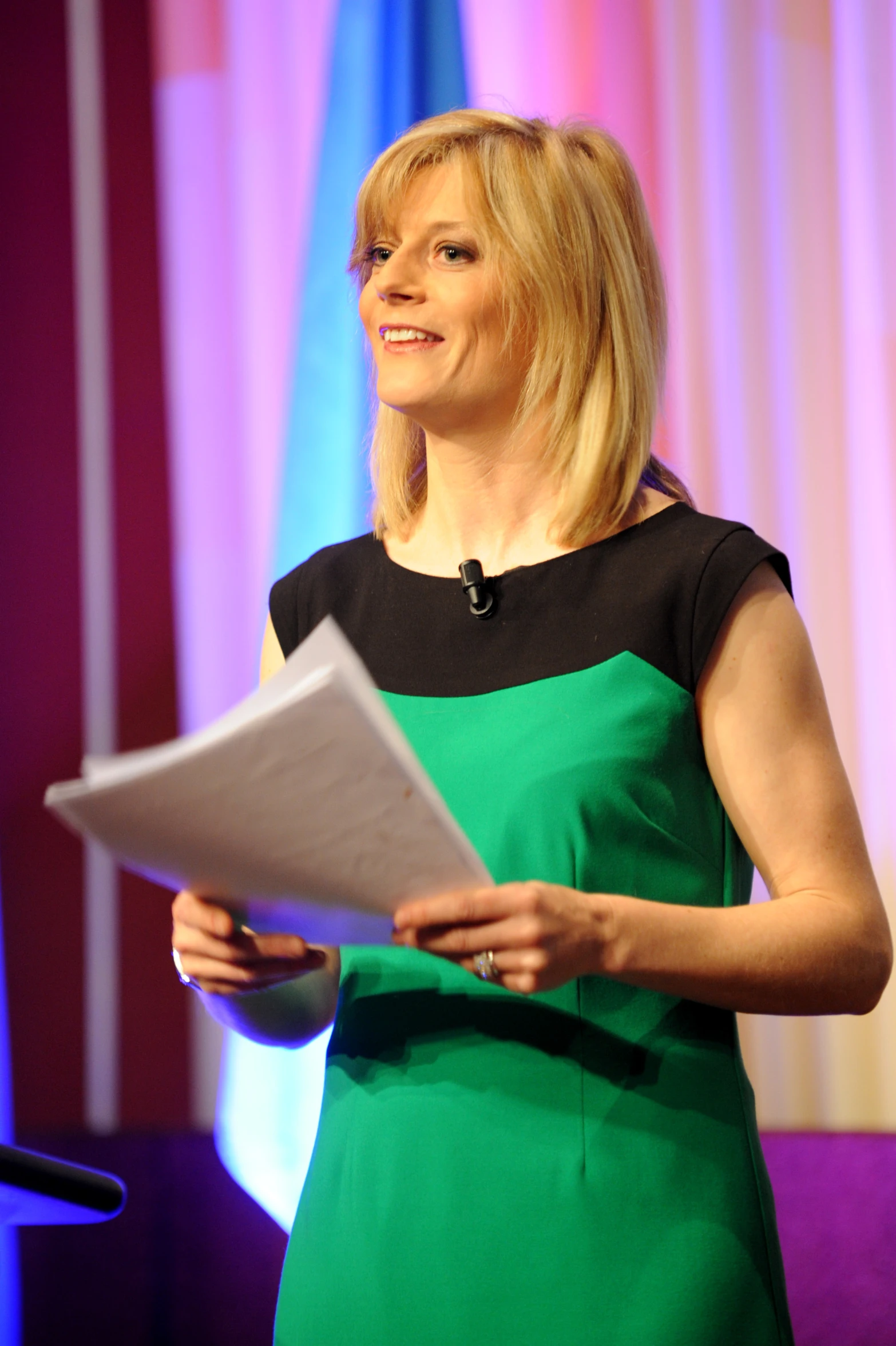 a woman stands and speaks at an event