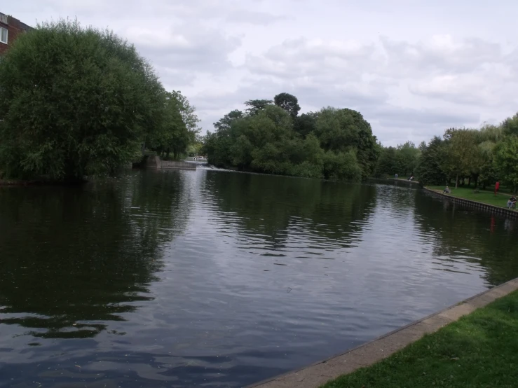 a river flowing through a city next to a park