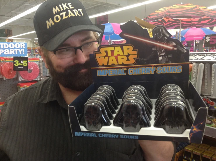 a man holding a display of chocolate candies with star wars designs